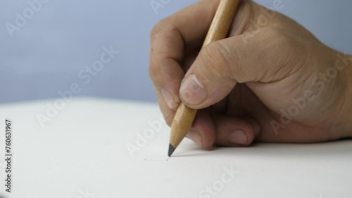 Hand is painted on the table on a sheet of white paper sketchbook.
Hold pencil writing to a blank drawing paper background.
Slow motion.