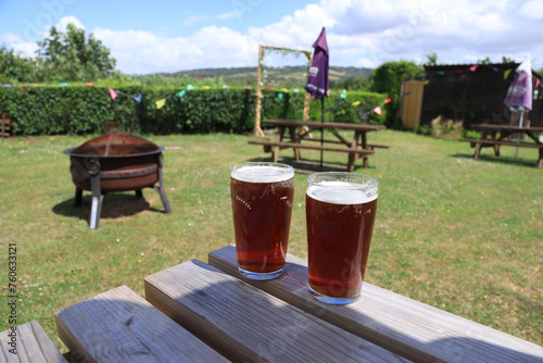 Pints of beer on a picnic bench in a pub garden on a summer’s day