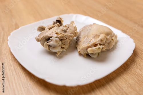 Boiled chicken meat is laid out on a white plate. Cooking chicken dishes.