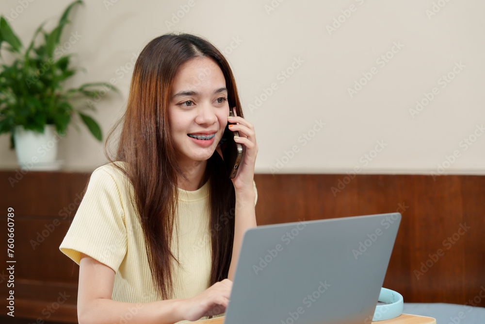 Engaged woman chats on phone, bright smile, laptop ready, indoor flora adding vitality to the setting. Content female in light sweater discusses over mobile, computer at hand, peaceful indoor plant Engaged woman chats on phone, bright smile, laptop ready, indoor flora adding vitality to the setting. Content female in light sweater discusses over mobile, computer at hand, peaceful indoor plant