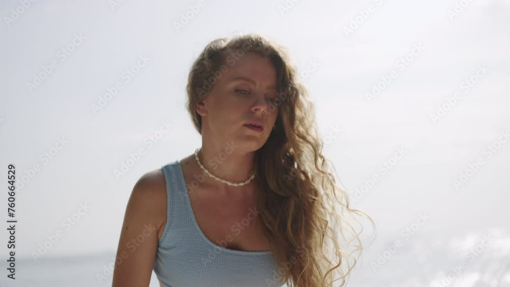 Woman emerges from ocean, grabs sunscreen bottle on beach for skin safety. Applies sunblock thoroughly, enjoys seaside holiday, prioritizes UV defense with SPF lotion. Slow motion. Woman emerges from ocean, grabs sunscreen bottle on beach for skin safety. Applies sunblock thoroughly, enjoys seaside holiday, prioritizes UV defense with SPF lotion. Slow motion.