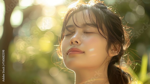 positive young woman with eye closed, enjoying sunlight 