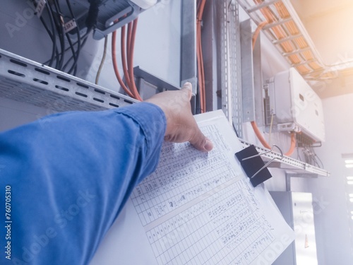 An inspector is pointing to the solar panel inverter module, having the concept of checking and monitoring the solar panel inverter. comissioning concept. photo