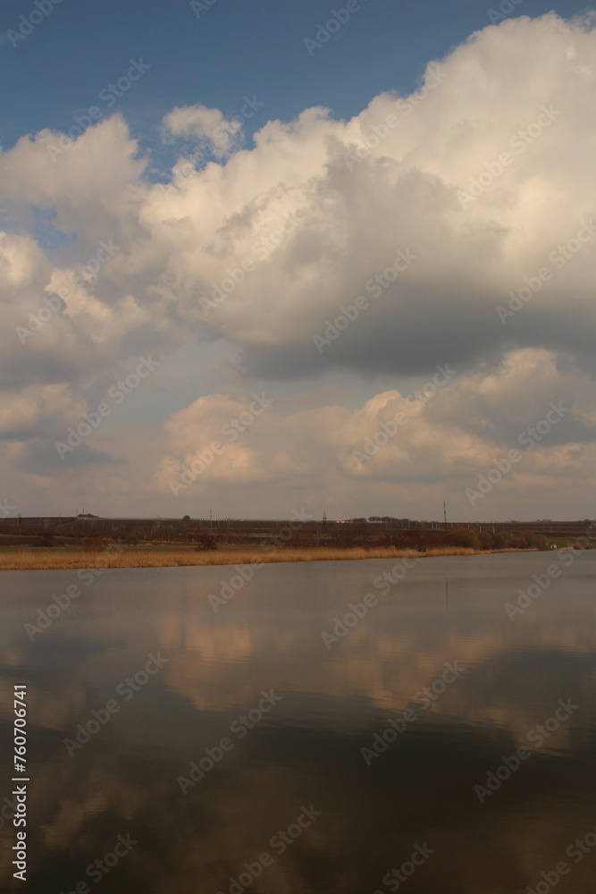 A body of water with clouds in the sky