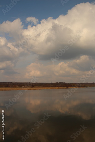 A body of water with clouds in the sky
