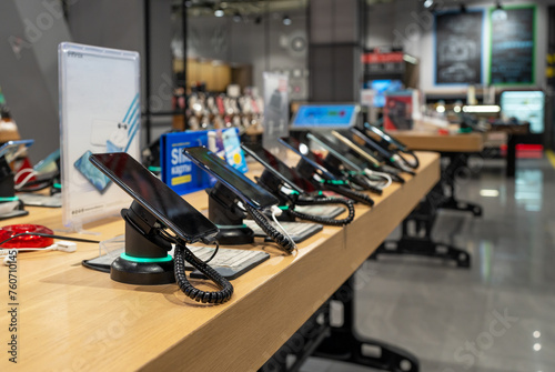 Showcase with smartphones in the modern electronics store. Buy a mobile phone. Many smartphones on the shelf of the technology store