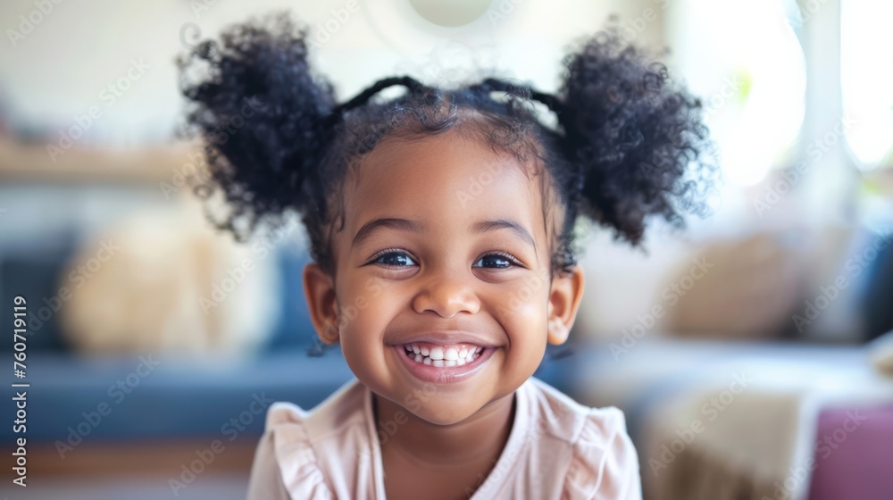 Smiling cute little African American girl with two pony tails looking at camera. Portrait of happy female child at home. Smiling face a of black 4 year old girl looking at camera with afro puff hair. - obrazy, fototapety, plakaty 