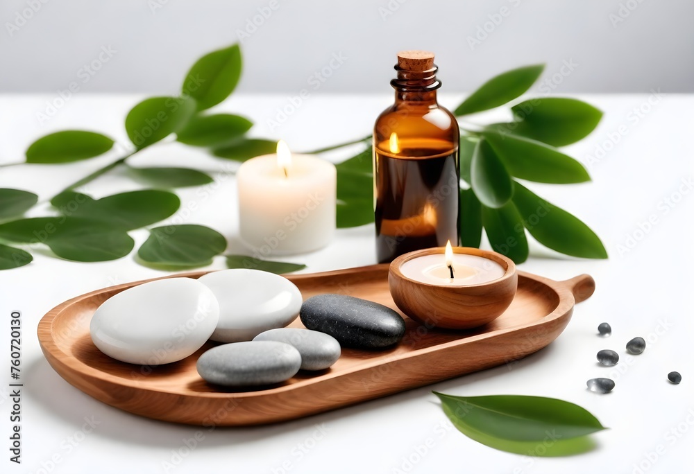candles on wooden stands, several massage stones, small glass bottles, and green leaves on a white surface candles on wooden stands, several massage stones, small glass bottles, and green leaves on a white surface