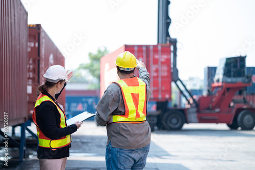 Engineers check the product list before sending it out at the industrial container yard.