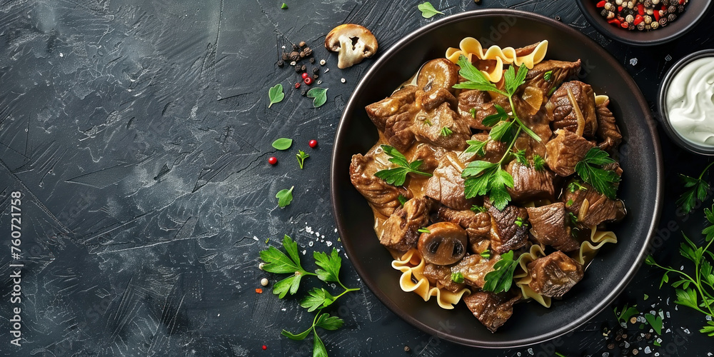 Delicious beef and pasta meal served in a sleek black plate on a dark background, top view shot
