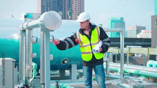 Engineer Analyzing Blueprints at Industrial Pipeline Site