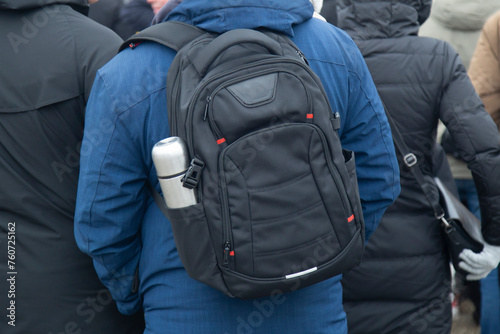 A man with a backpack on his shoulders on a city street.