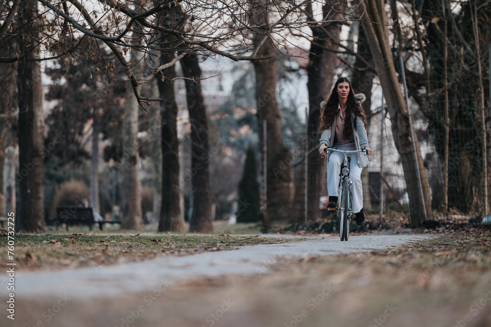 Professional woman unwinding with a peaceful bicycle ride amidst the serene park environment.