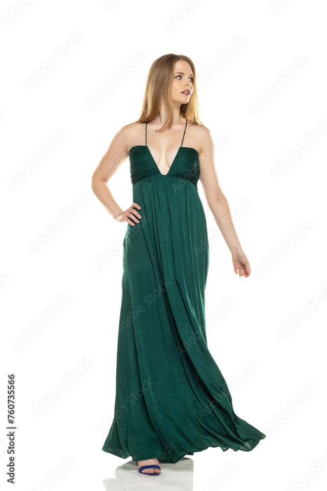 Full body front view portrait of elegant lovely blond lady  walking isolated on white background in green long dress