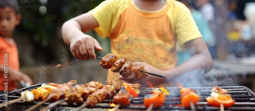family cooking tasty food on barbecue grill photo