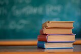 Close-up of a stack of school textbooks books on a wooden table against the background of a blurred educational chalkboard in classroom. Concept of back to school, learning, school times, banner with 
