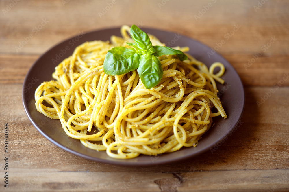 Spaghetti with pesto sauce. Pasta al pesto plate on wood table Spaghetti with pesto sauce. Pasta al pesto plate on wood table