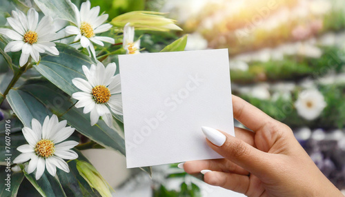 Blank white square card held by female hand.