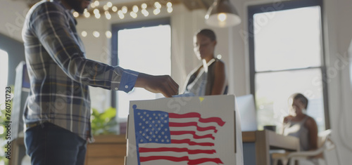 A man is holding a box featuring the American flag design. The mans hand grips the box firmly as the flag waves proudly on its surface.