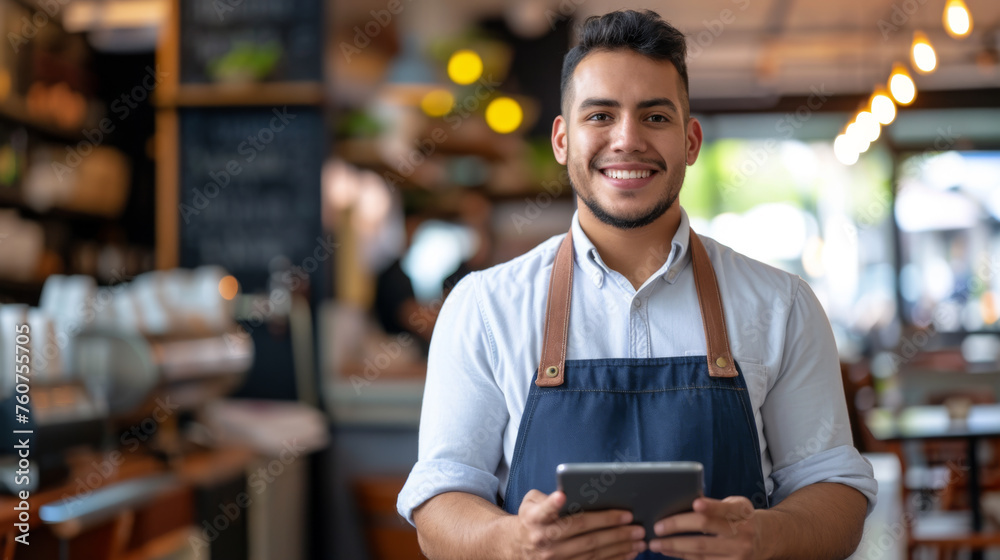 smiling young man standing in a restaurant, holding a tablet smiling young man standing in a restaurant, holding a tablet