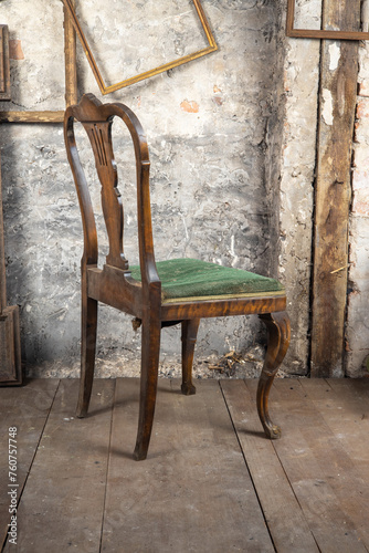 Defective old broken chair in an old dirty room with other vintage things