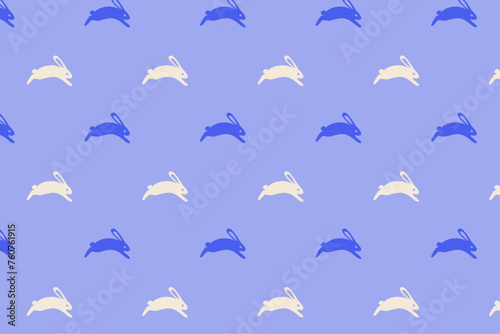Seamless pattern with white and blue rabbits on violet background. Easter and spring theme design for textile, wallpaper, and wrapping paper