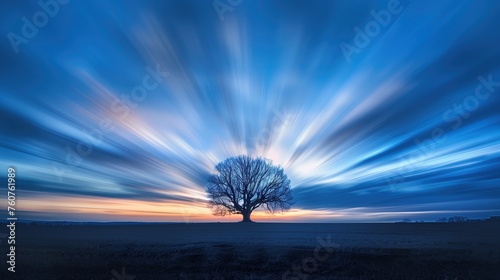Samotne drzewo na tle niebieskiego nieba o zmierzchu w stylu dramatycznego long exposure i low angle. Kontrast między ciemnym drzewem a jaskrawym niebem.