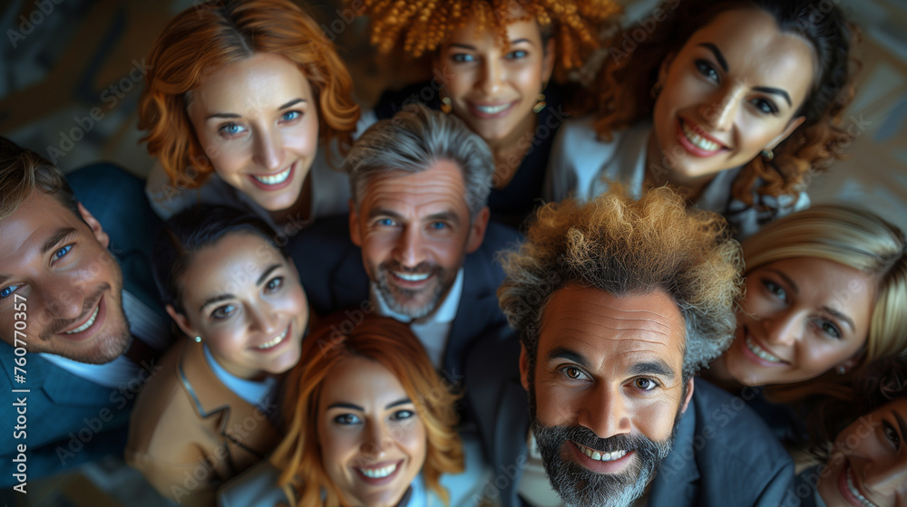 Top view high angle shot from above group portrait of businesspeople standing together, looking up at camera and smiling.