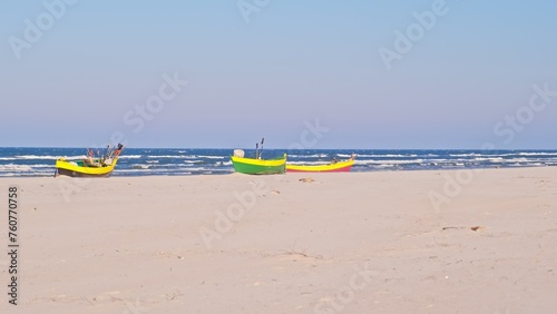 Undecked Handliner Fishing Vessel with Net Flags and Rusty Hooks Purse Sein Equipment Parked on Beach Sand at Seashore on Windy Spring Day