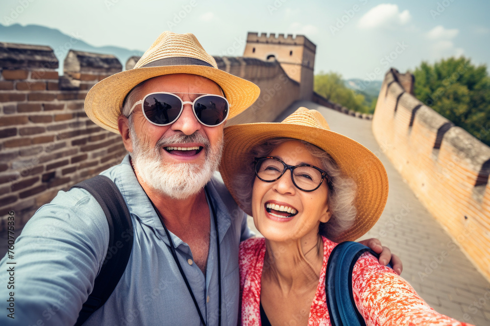 A happy elderly tourist couple take a selfie in China with the Great Wall in the background. Travel retirement concept. AI generated.