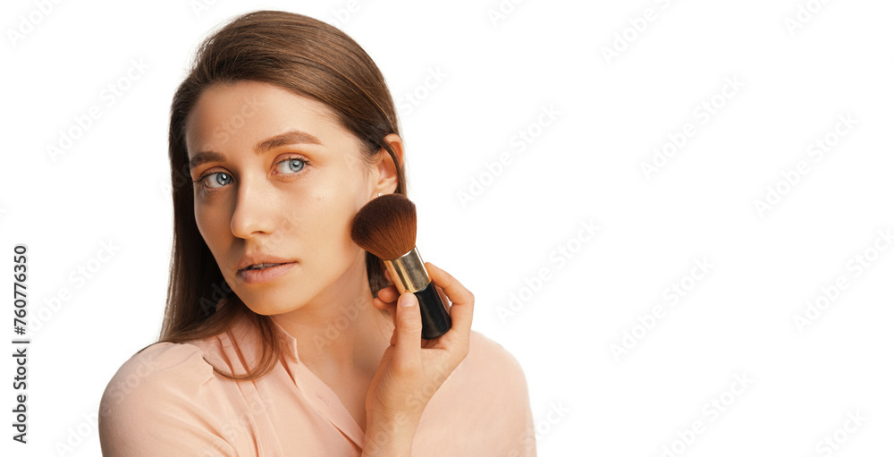 Studio portrait of a young woman applying face powder with a beautiful brush. Copy space aside. Studio portrait of a young woman applying face powder with a beautiful brush. Copy space aside.