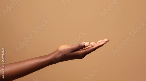 Close-up of african american woman hand with palm facing upwards isolated on brown background.
