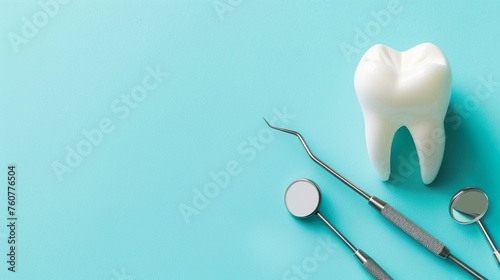 Model of tooth and dental instruments on a light blue background with space for text. © Kasorn