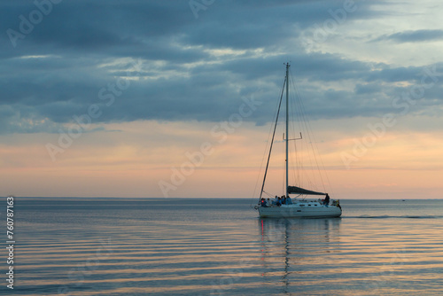 Long exposure image of dramatic sky seascape with a sailing yacht in sunset scenery background and a sailing yacht © juriskraulis