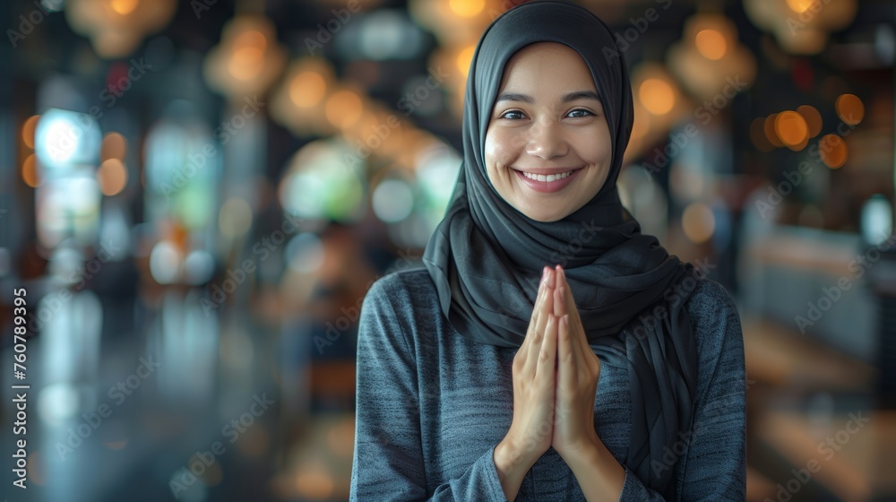 Asian muslim woman smiling, making eid mubarak gesture on blurred background with text space - obrazy, fototapety, plakaty 
