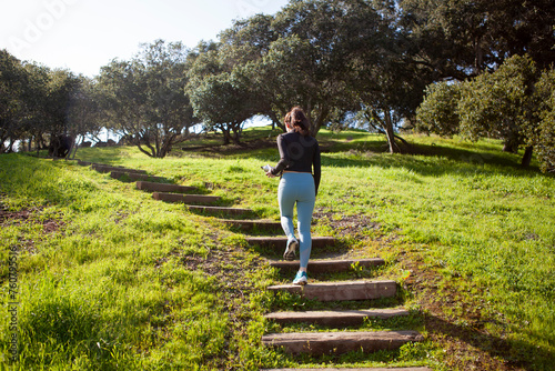 Young woman jogging exercising outdoors, walking up steps