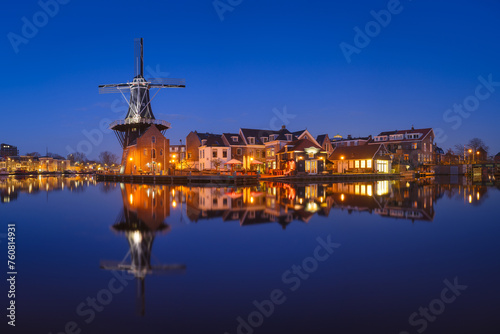 The windmill De Adriaan, Haarlem, Netherlands. Historic buildings. Cityscape during the blue hour. Reflections on the surface of water. Panorama. Picture for background and wallpaper. © biletskiyevgeniy.com
