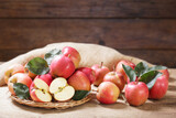 fresh red apples with leaves on wooden table