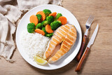plate of grilled salmon, rice and vegetables, top view