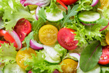 green salad and fresh vegetables as background, top view