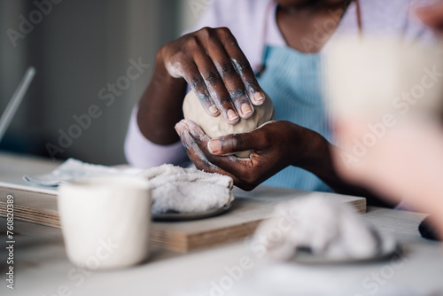 Cropped picture of interracial craftswoman's hands making earthenware