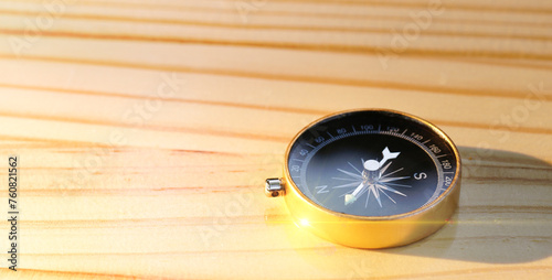 Gold compass on wooden table background, navigation concept, learning guideline, Travel. Close up with copy space.