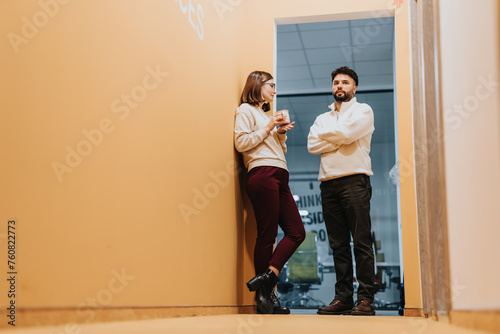 Young, confident colleagues discussing business growth strategies and sharing ideas in an office.