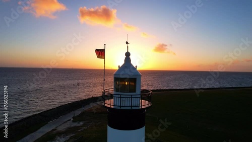 Lighthouse in the sunset - Wremen - Little Prussia lighthouse - backwards flight Aerial view from the sunset over the sea with the lighthouse photo