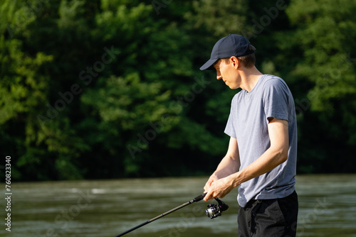 Man fishing on the mountain river at evening