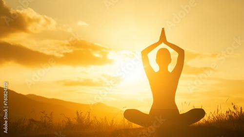 Person in yoga meditation pose in a serene field against a stunning sunset