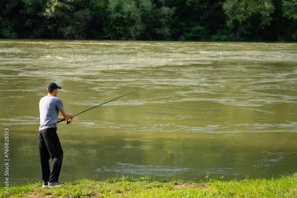 Man fishing on the mountain river at evening Man fishing on the mountain river at evening