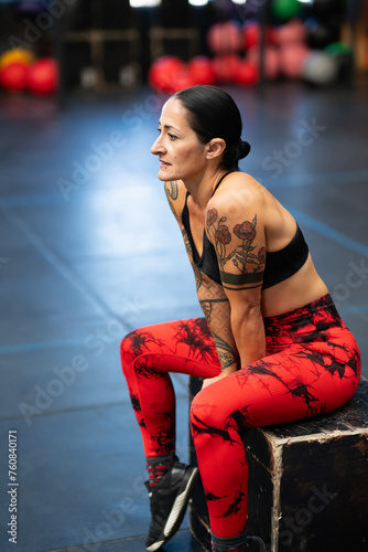 Mature fit woman sitting on a box resting after training