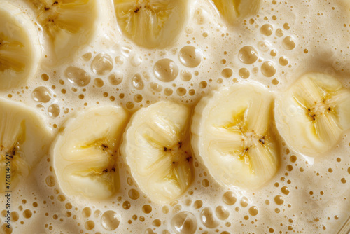 Close up of Fresh Banana Milkshake with Fruit Slices Detail Texture Background. Macro Top View of Fruity Yellow Milk Shake or Healthy Juicy Smoothie Backdrop. Yummy Summer Drink Mix Surface Wallpaper 