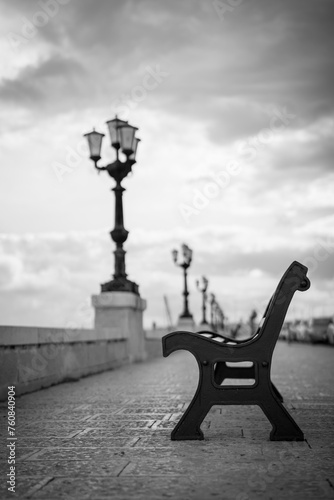 Black and white photo of a wooden bench on the Adriatic seafront, Bari, Italy